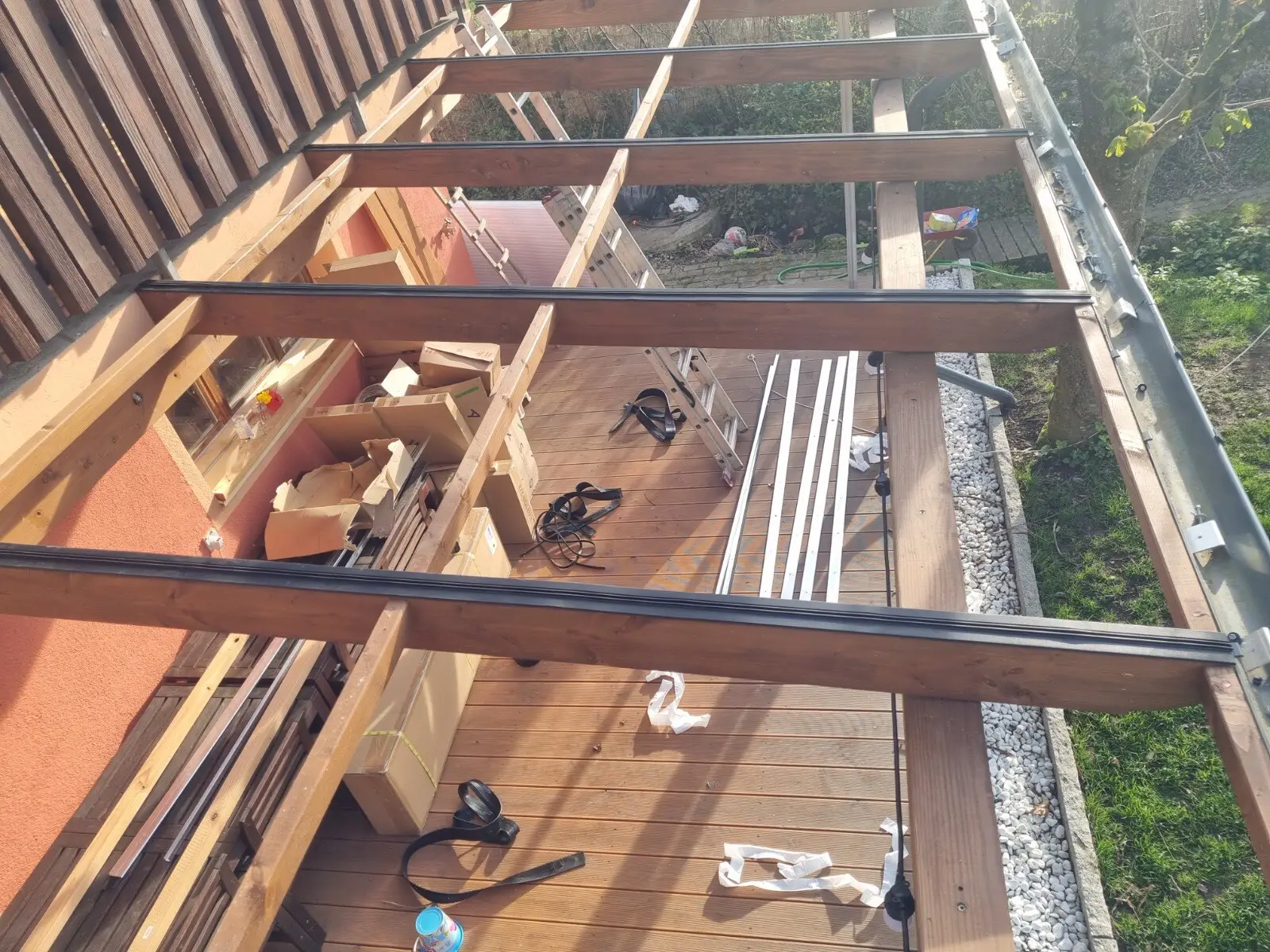 Montage einer Terrassenüberdachung mit Holzterrasse und Aluminiumprofilen
